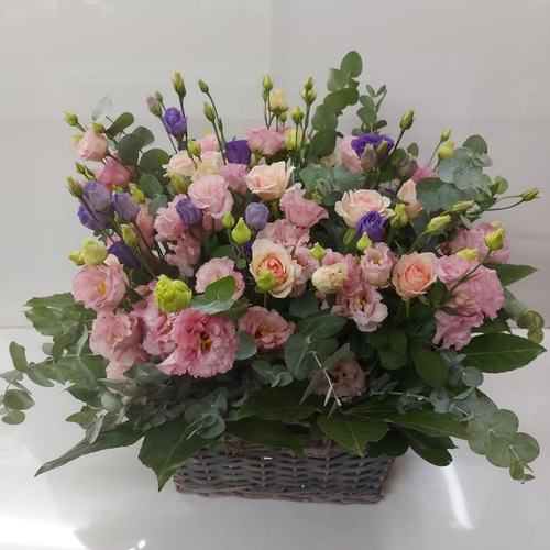סידור פרחים בסלסלה מרהיב שזור  ליזיאנטוס צבעוני  וורדים